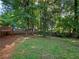 Back yard with mature trees and a wood fence at 975 Memory Ln, Lawrenceville, GA 30044