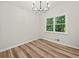 Bright bedroom with hardwood floors, modern light fixture, and a large window overlooking the lush exterior at 975 Memory Ln, Lawrenceville, GA 30044
