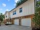 Close view of a home highlighting stone accents and an attached two-car garage with an outdoor staircase at 975 Memory Ln, Lawrenceville, GA 30044