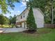 Exterior side view of a home with a stone facade on the lower level with a two-car garage and landscaping at 975 Memory Ln, Lawrenceville, GA 30044