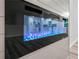 A close-up of a modern electric fireplace with blue flames against a sleek, gray accent wall at 975 Memory Ln, Lawrenceville, GA 30044