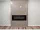 Modern fireplace with a sleek black firebox surrounded by a gray paneled wall and hardwood flooring at 975 Memory Ln, Lawrenceville, GA 30044