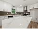 Modern kitchen boasts white cabinets, quartz countertops, stainless steel appliances, and tile backsplash at 975 Memory Ln, Lawrenceville, GA 30044