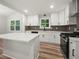 Bright kitchen features white cabinetry, stainless steel appliances, a center island, and a stylish backsplash at 975 Memory Ln, Lawrenceville, GA 30044