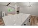 Open-concept living area with a white island, wooden beam, modern chandelier, and hardwood flooring at 975 Memory Ln, Lawrenceville, GA 30044