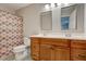 Functional bathroom with a double vanity, shower with patterned curtain, and convenient toilet at 174 Rivertown Rd, Fairburn, GA 30213