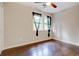 Cozy bedroom with hardwood floors, a ceiling fan, natural light, and a large window, ideal for relaxation at 174 Rivertown Rd, Fairburn, GA 30213