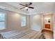 Comfortable bedroom with hardwood floors, large windows, ceiling fan, and an ensuite bathroom at 174 Rivertown Rd, Fairburn, GA 30213