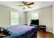 Cozy bedroom features a ceiling fan and hardwood floors at 174 Rivertown Rd, Fairburn, GA 30213