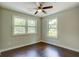 Bright bedroom features dark hardwood floors and a ceiling fan at 174 Rivertown Rd, Fairburn, GA 30213