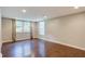 Well-lit empty room with hardwood floors, perfect for customization and ample space for various uses at 174 Rivertown Rd, Fairburn, GA 30213