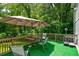 Outdoor wooden deck with artificial turf and seating under an umbrella, perfect for relaxation at 174 Rivertown Rd, Fairburn, GA 30213