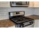 Close up of stainless steel oven and gas range with granite countertops and subway tile backsplash at 238 Walker Sw St # 32, Atlanta, GA 30313