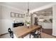 Inviting dining room with a wooden table, black chairs, chandelier, and kitchen view at 4371 Wigley Preserve Dr, Marietta, GA 30066