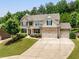 Charming two-story home with manicured lawn, three-car garage, and inviting front porch at 4371 Wigley Preserve Dr, Marietta, GA 30066