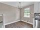 Bright dining area features hardwood floors, modern chandelier, and natural light from window at 8989 Teal Ln, Jonesboro, GA 30236
