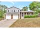 Two-story home featuring a well-manicured front yard, stone accents, and a two-car garage at 8989 Teal Ln, Jonesboro, GA 30236