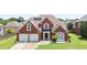 Charming two-story brick home features a well-manicured lawn and two-car garage at 3735 Turnbury Oaks Dr, Peachtree Corners, GA 30096