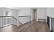 Upstairs hallway featuring hardwood floors and iron balusters at 3735 Turnbury Oaks Dr, Peachtree Corners, GA 30096