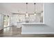 Well-lit kitchen featuring white cabinetry, modern appliances and hardwood flooring at 3735 Turnbury Oaks Dr, Peachtree Corners, GA 30096
