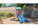 Bright, colorful playground featuring two blue slides, climbing structures, and a green awning for shade at 3735 Turnbury Oaks Dr, Peachtree Corners, GA 30096