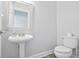 Classic powder room with pedestal sink and white fixtures at 3735 Turnbury Oaks Dr, Peachtree Corners, GA 30096