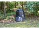 Backyard with a black compost bin surrounded by grass and trees at 150 Ashley Dr, Fayetteville, GA 30214