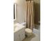 Bathroom with a white vanity sink, a toilet with a furry seat cover, and a shower with a tan shower curtain at 150 Ashley Dr, Fayetteville, GA 30214