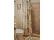 Bathroom with a toilet and a shower with beige and green floral shower curtain at 150 Ashley Dr, Fayetteville, GA 30214
