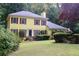Charming two-story home featuring a manicured lawn, mature trees and flower beds at 150 Ashley Dr, Fayetteville, GA 30214