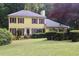 Beautiful yellow home with manicured lawn and mature shrubbery at 150 Ashley Dr, Fayetteville, GA 30214