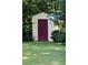 Yellow shed with maroon door in backyard with grass and trees at 150 Ashley Dr, Fayetteville, GA 30214