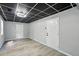 Basement space featuring a drop ceiling, gray walls, wood-look flooring, and white doors and trim at 4076 Whistler Dr, Douglasville, GA 30135