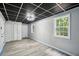 Finished basement featuring a drop ceiling, gray walls, wood-look flooring and natural light through windows at 4076 Whistler Dr, Douglasville, GA 30135
