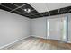 Basement space featuring a drop ceiling, gray walls, wood-look flooring, and a white exterior door with sidelights at 4076 Whistler Dr, Douglasville, GA 30135