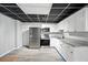 Basement kitchen featuring a drop ceiling, white cabinets, stainless steel appliances, and wood-look flooring at 4076 Whistler Dr, Douglasville, GA 30135