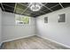 Basement space featuring a drop ceiling, gray walls, and wood-look flooring with a window at 4076 Whistler Dr, Douglasville, GA 30135