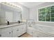 Bright bathroom features a soaker tub, double vanity and a view to the outdoors at 4076 Whistler Dr, Douglasville, GA 30135