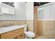 Bathroom featuring a single sink vanity, marble countertops, toilet, and shower with natural stone tile at 4076 Whistler Dr, Douglasville, GA 30135