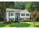 Charming home with white siding, black shutters, and a beautifully landscaped front yard with mature trees at 4076 Whistler Dr, Douglasville, GA 30135
