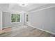 Spacious main bedroom featuring natural light, tray ceiling, wood-look laminate flooring and neutral-toned walls at 4076 Whistler Dr, Douglasville, GA 30135