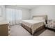 Bright bedroom with a neutral palette, featuring a patterned chair, a dresser, and soft carpeting at 108 Berwick Crossing, Dallas, GA 30157