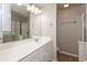 Bright bathroom with a spacious white vanity, large mirror, updated lighting, and shower with glass doors at 11768 Wellsley Way, Johns Creek, GA 30005