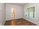 Neutral bedroom features wood-look floors, a window with blinds, and an ensuite bathroom for added convenience at 11768 Wellsley Way, Johns Creek, GA 30005