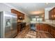 Kitchen with stainless steel appliances, wood cabinets, and view to the living room at 11768 Wellsley Way, Johns Creek, GA 30005