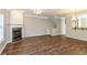 Open living room with fireplace, wood floors, ceiling fan, and bar-style seating at 11768 Wellsley Way, Johns Creek, GA 30005