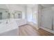 Bright bathroom featuring double vanities, soaking tub, and glass-enclosed shower at 3961 S River Ln, Ellenwood, GA 30294