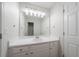 A stylish bathroom features a white vanity, modern lighting, and a large mirror with a door adjacent at 3961 S River Ln, Ellenwood, GA 30294