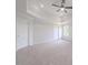 Large carpeted bedroom featuring a tray ceiling and a ceiling fan at 3961 S River Ln, Ellenwood, GA 30294