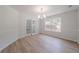 Bright dining room features modern chandelier, neutral paint, and light wood floors at 3961 S River Ln, Ellenwood, GA 30294